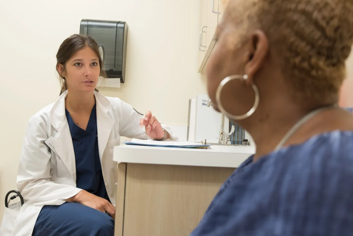 Clinician speaking with a patient in an exam room